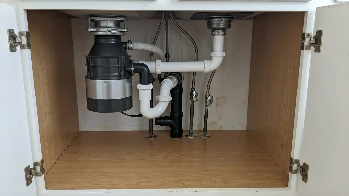 After: A leaking disposal replaced | Music City Appliance Repairs After: an under-sink cabinet with a new disposal installed with tight, neat plumbing and a dry cabinet floor